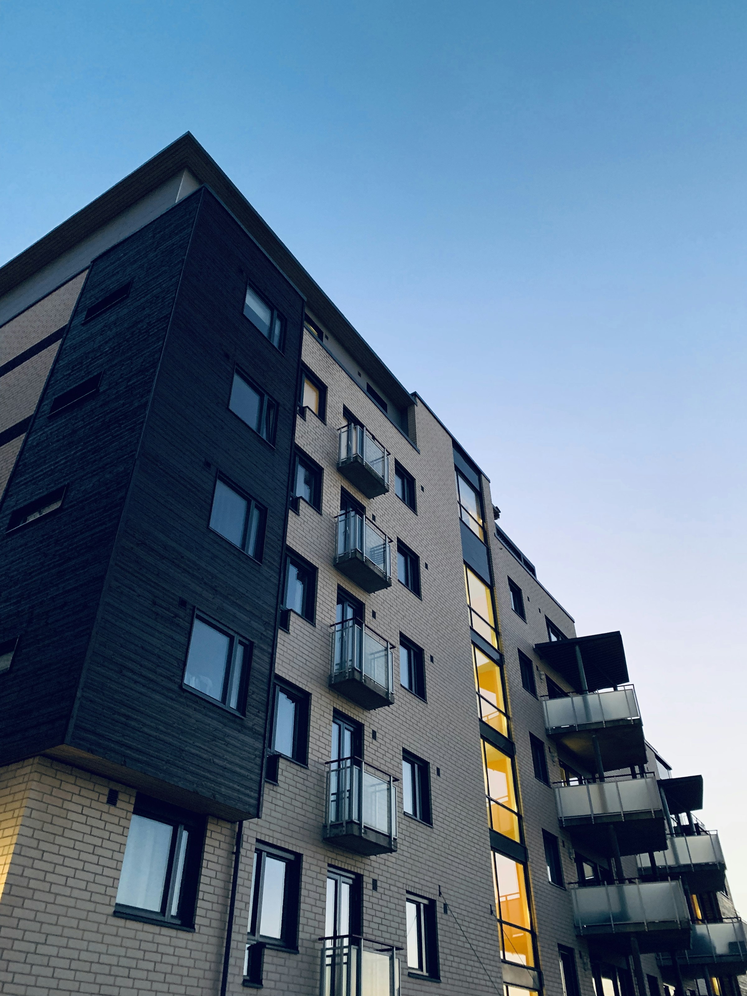 Apartment building at dusk with warm light in the windows